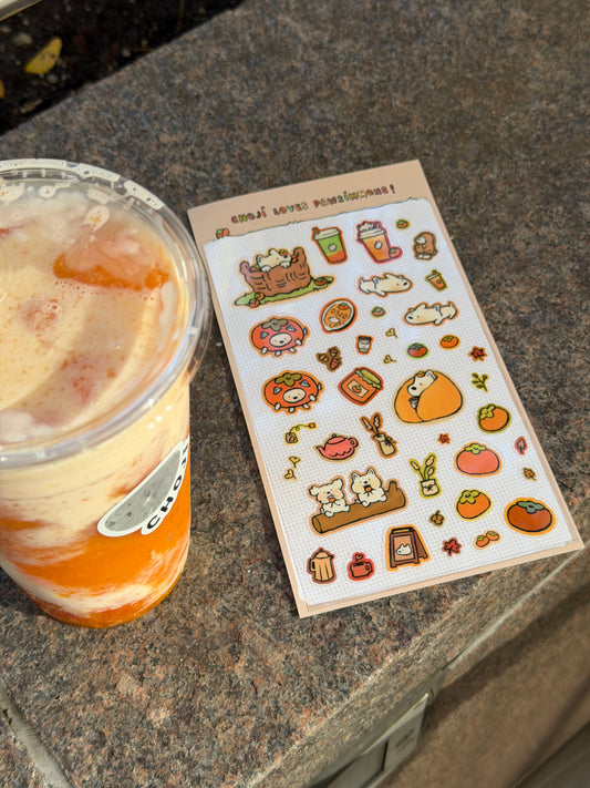 Choji Loves Pawsimmons sticker sheet beside an iced drink